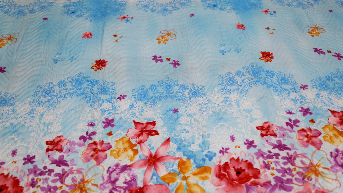 Close-up of pink and orange roses printed on sky blue quilted cotton