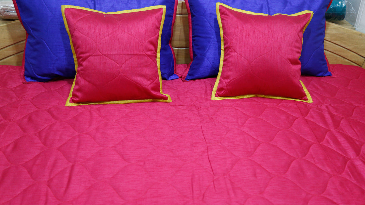 Close-up of crimson cushion covers on the crimson quilted side