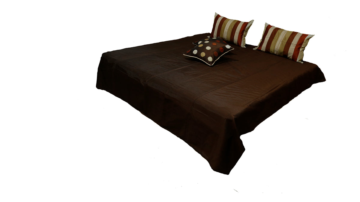 Dark brown bedcover with a single polka-dot cushion at the foot, Circle Design