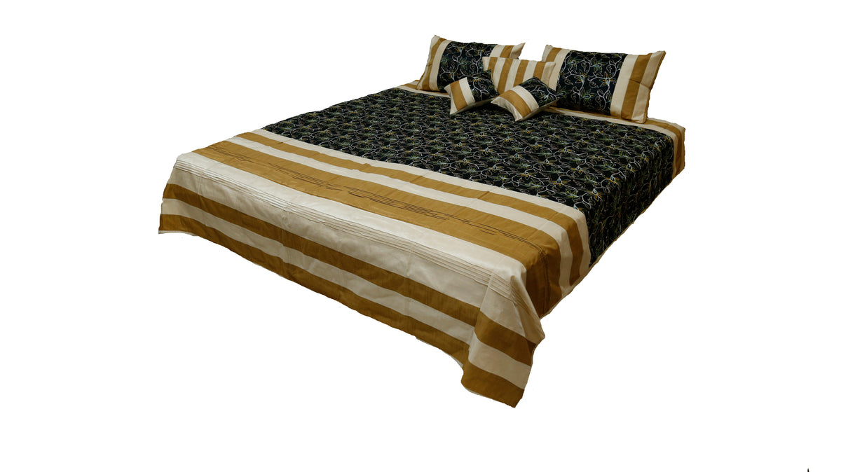 Black and gold banded aari embroidery bedcover seen from the foot of the bed