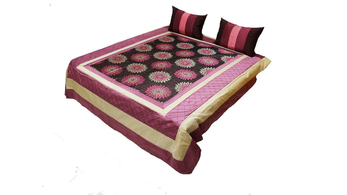 Wine and black lotus print bedcover on a bed with two striped cushion covers, angled