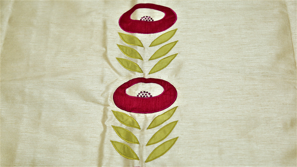 Close up of the cream fabric with a crimson and green embroidered flower on a stem