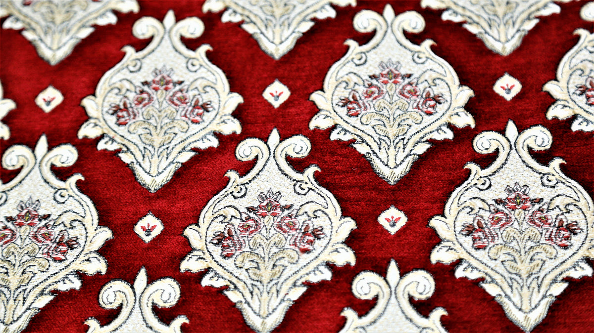Close up of deep red fabric with cream damask medallions and fine floral fill