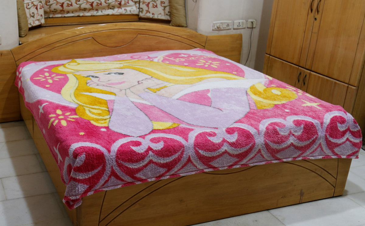 Pink and lilac blanket with a printed Disney Princess Aurora design and a scroll-heart border, draped over a bed