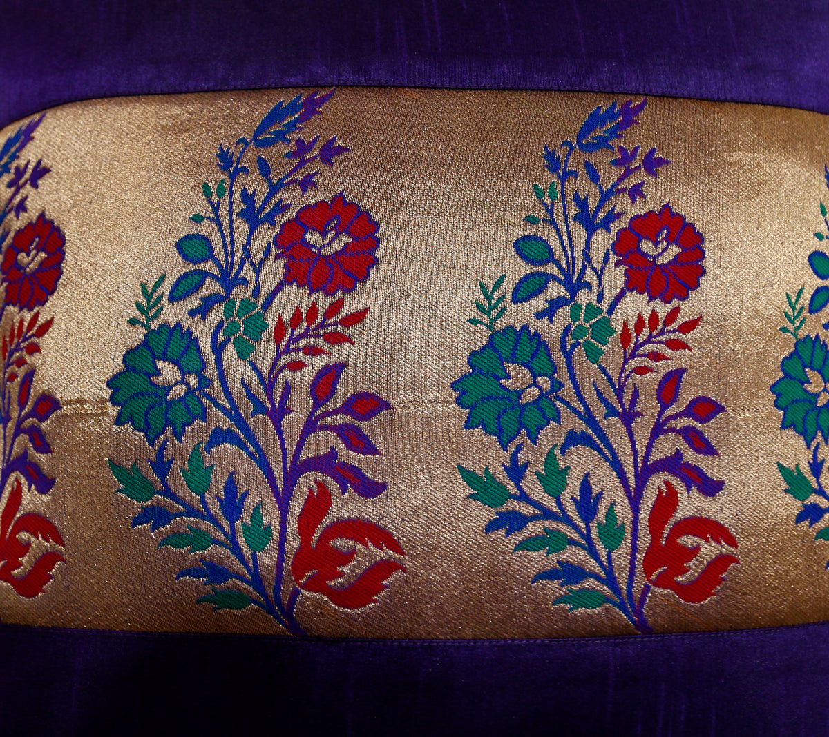 Close-up of the gold brocade panel with red, blue and teal woven flowers