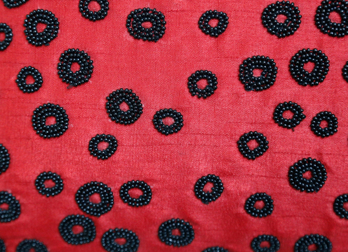 Close up of the black beaded rings worked on the red ground