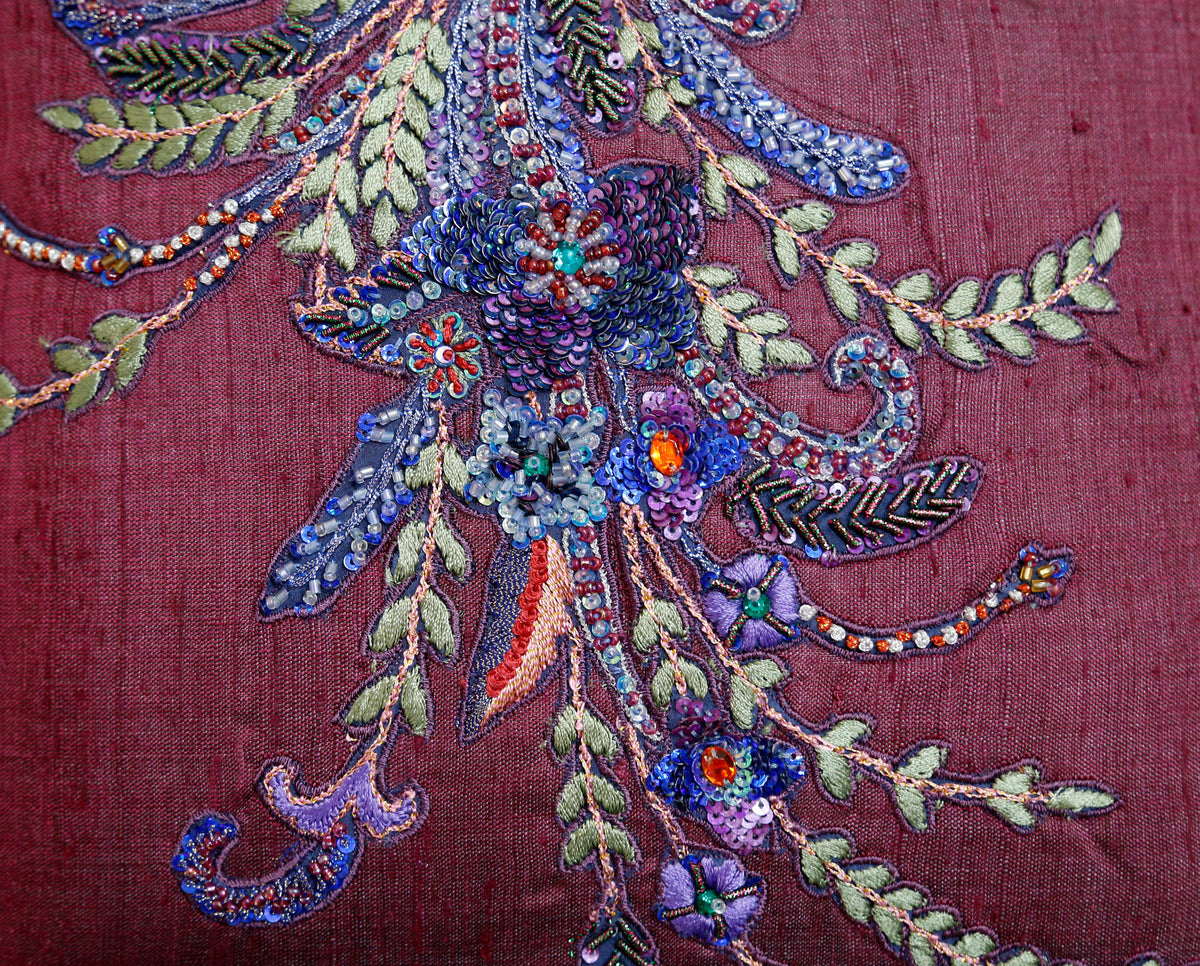 Close up of the beaded and sequinned floral spray on the plum cushion cover
