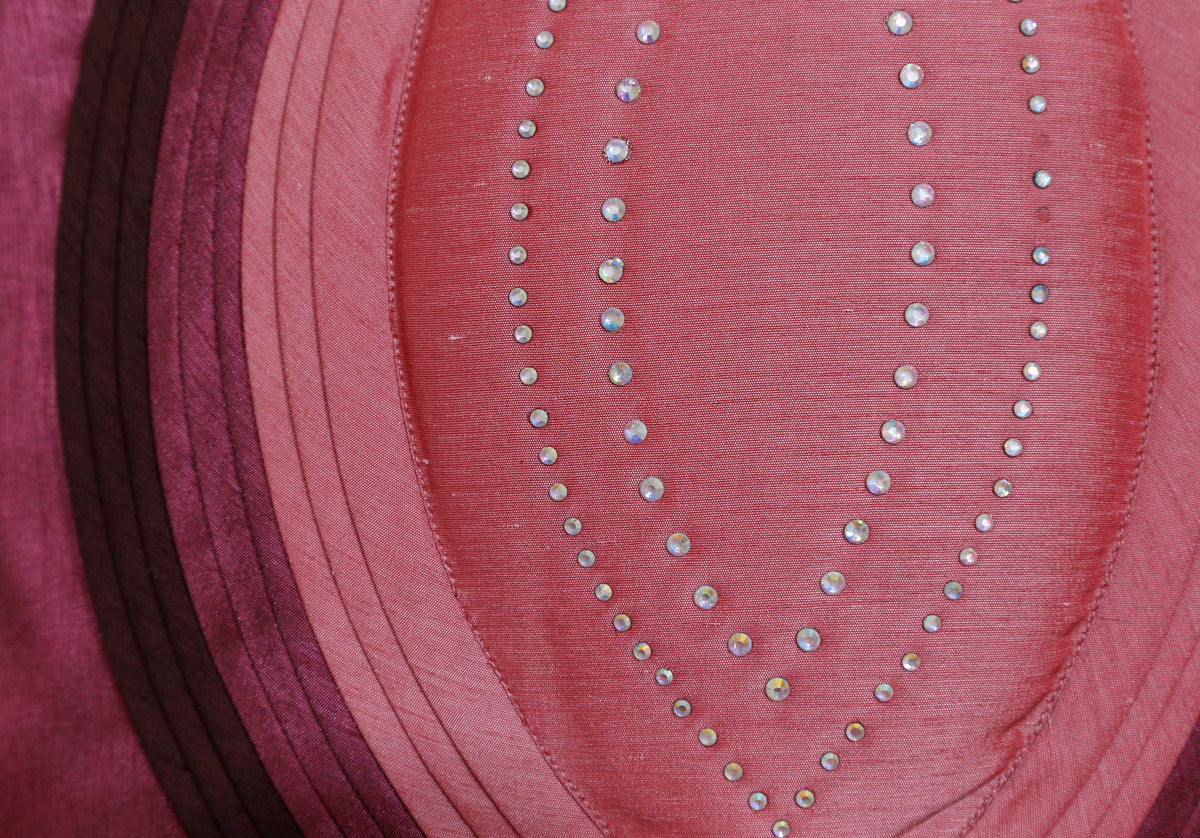 Close-up of the coral pink appliqué panels and silver stone work