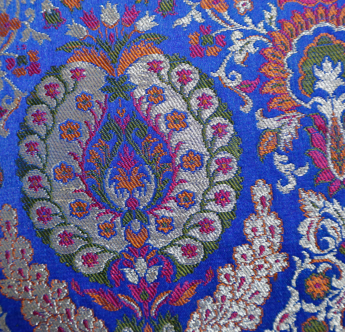 Close up of the royal blue brocade with multicolour woven paisley medallions
