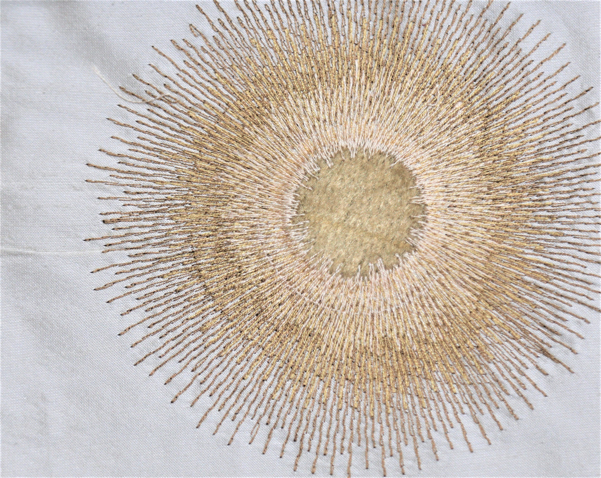 Ivory silk upholstery fabric with a rich gold embroidered sunburst motif