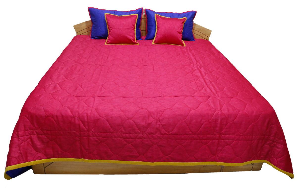 Crimson quilted side laid flat with blue and crimson gold edged cushion covers