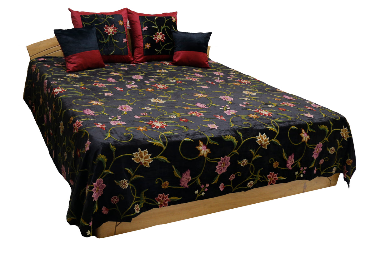 Black velvet double bedcover with a multicolour crewel floral embroidery, styled with 4 matching cushion covers in maroon and black velvet