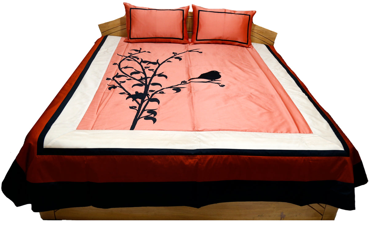 Coral bedcover with black bird and branch applique, rust and black borders